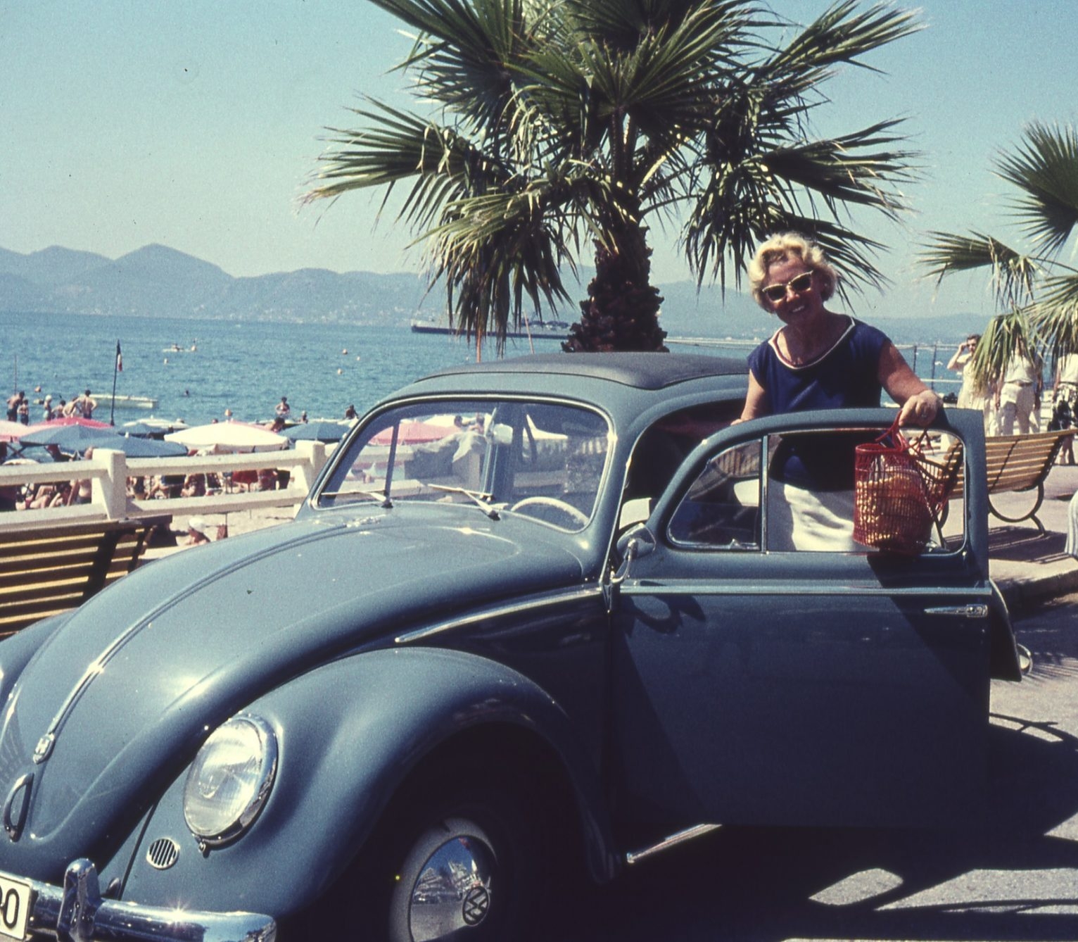 Frau steht neben ihrem Auto an der italienischen Riviera.